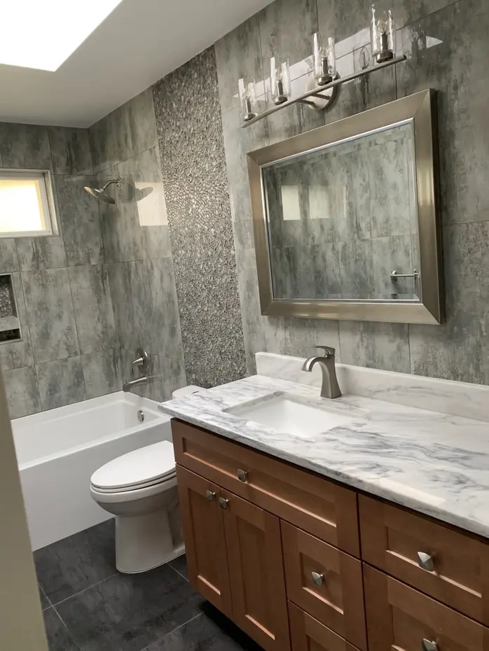 Marble tile walk-in shower with mosaic accent strip and hexagon floor