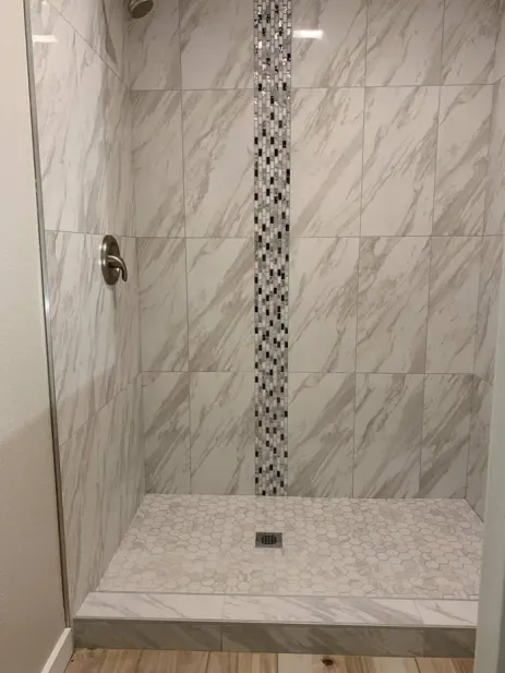 Bathroom renovation with marble vanity and pebble accent wall