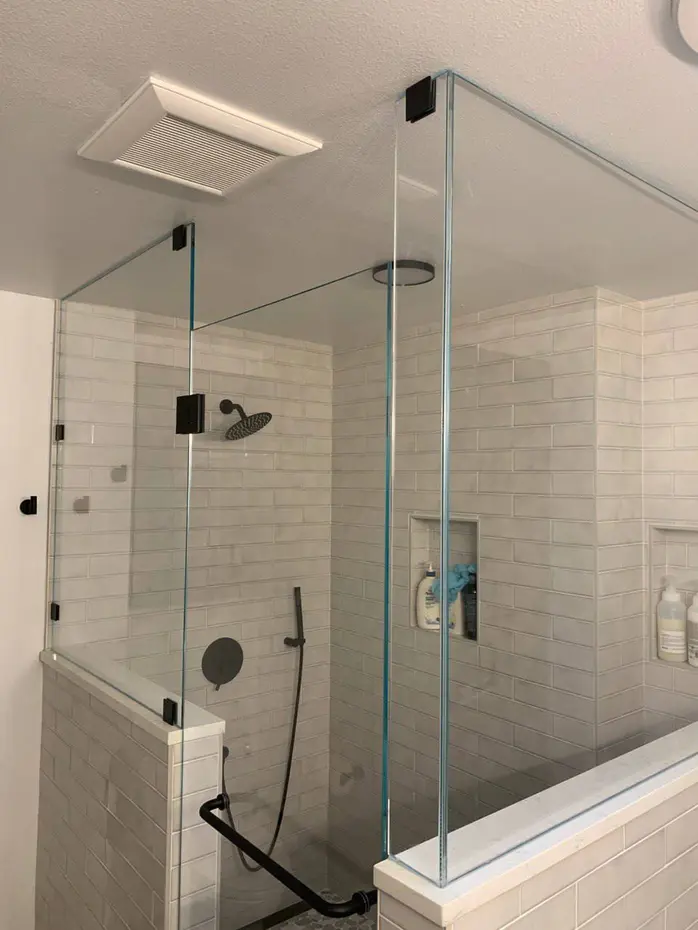 Modern dark bathroom remodel with skylight and pebble shower floor