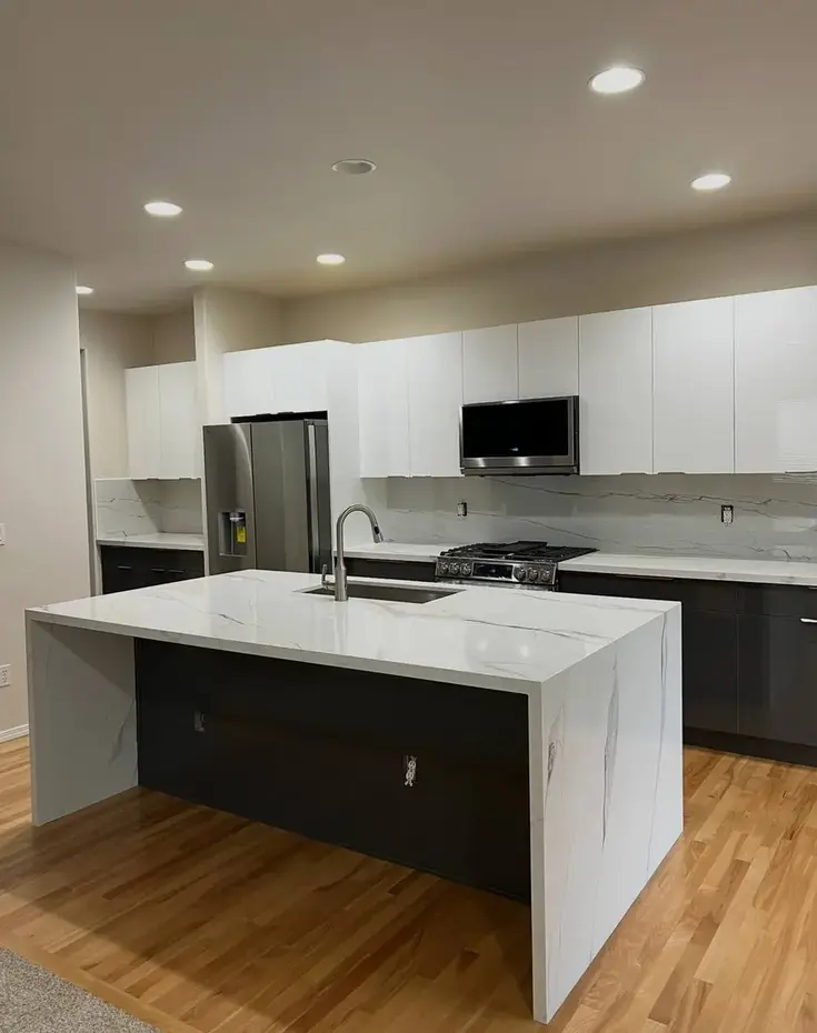 Super white quartzite countertop kitchen remodel with dark tile floor